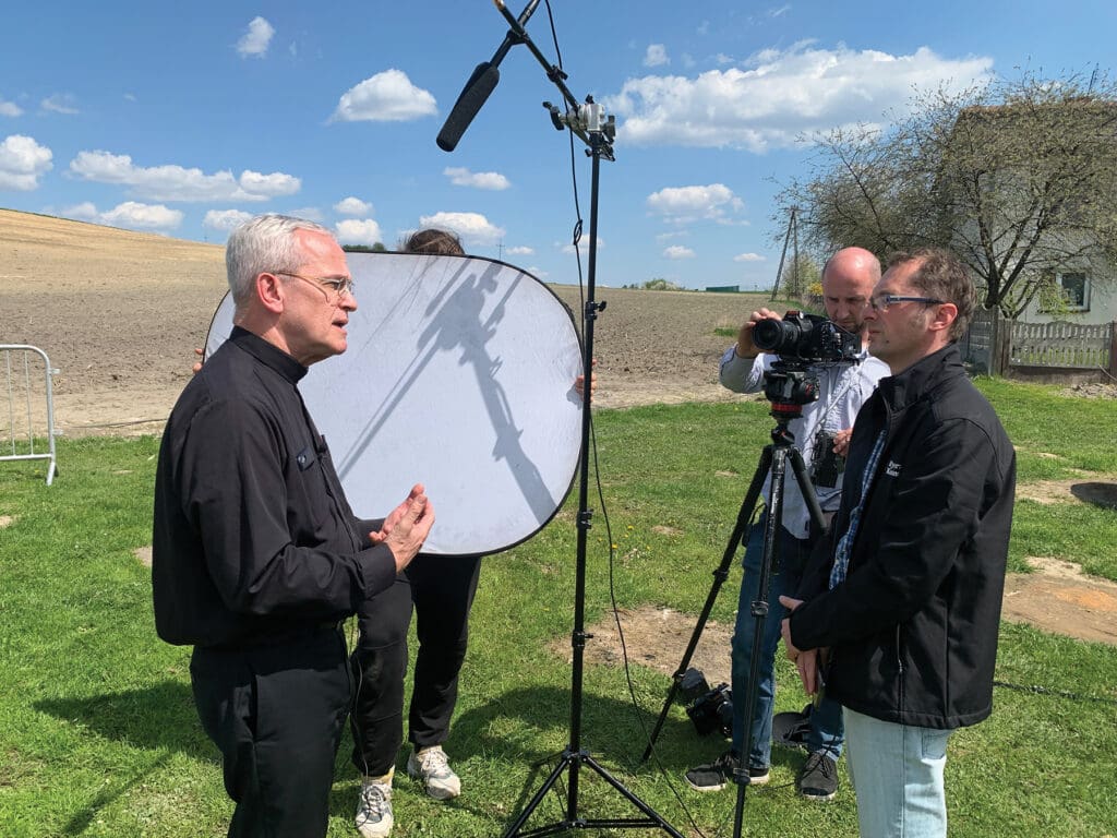 Msgr. Peter I. Vaccari, CNEWA president, is interviewed by the press in Hrebenne, Poland.