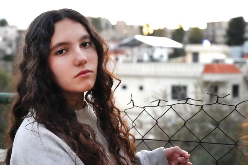 Close up of a young girl holding a fence, Lebanon.